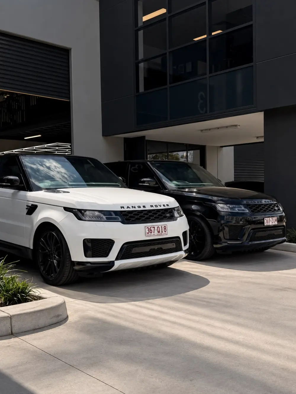 Two SUVs parked outside a vehicle dealership